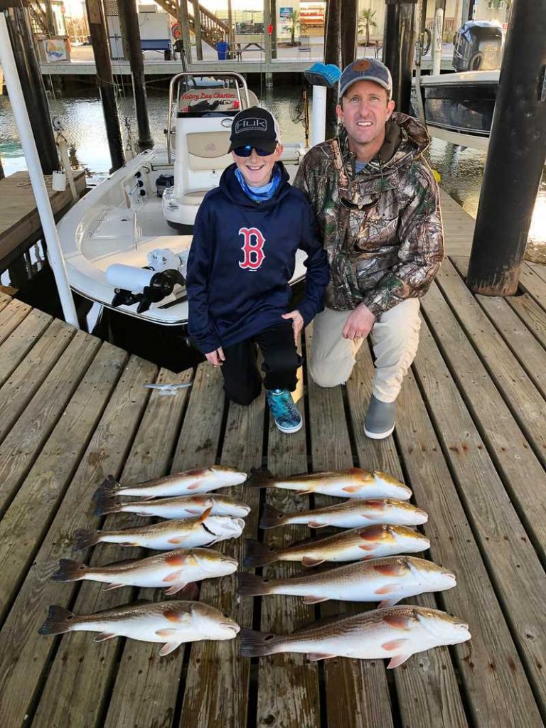 father and son with redfish charter fishing in the Rigolets near Slidell