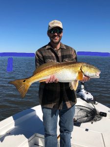 fisherman holding a large redfish on fishing trip with Victory Bay Charters