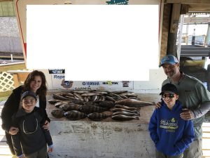 Family posing with fish that were caught