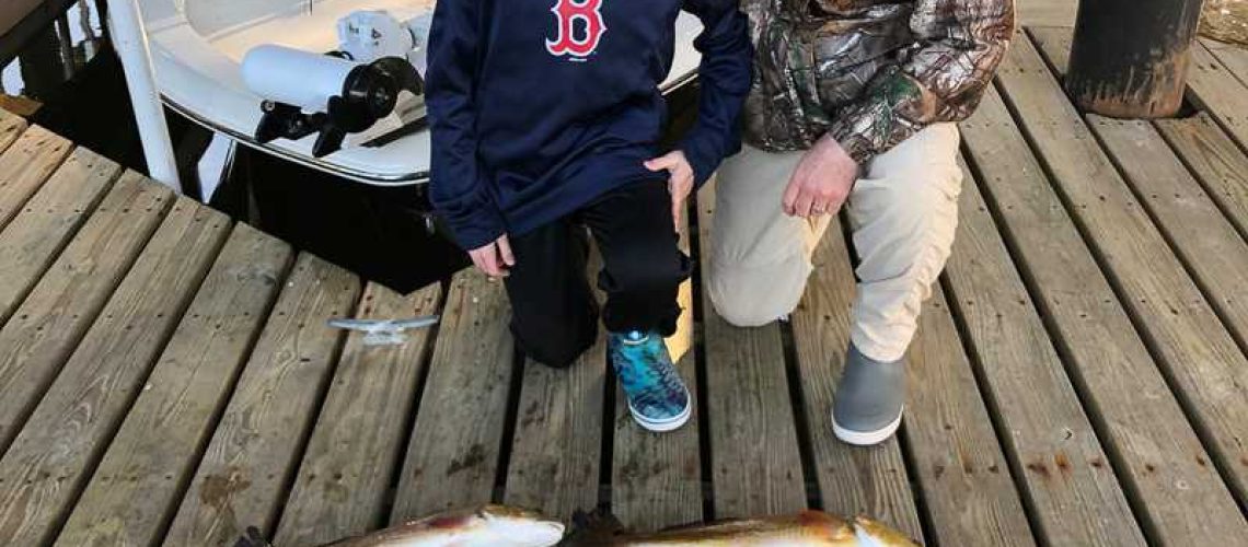 father and son with redfish charter fishing in the Rigolets near Slidell