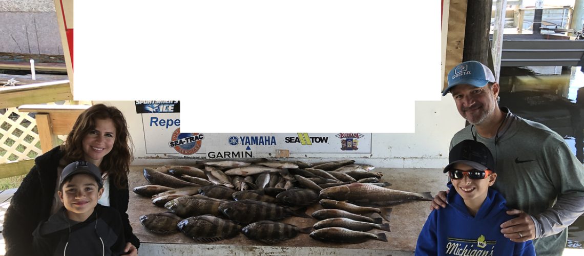Family posing with fish that were caught